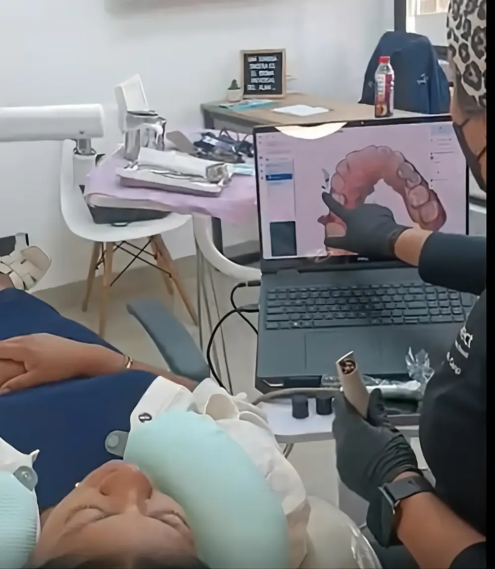 Escaneo intraoral de una paciente con la imagen 3D en la laptop